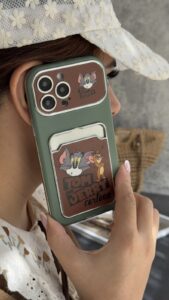 قاب موبایل آیفون تام و جری سبز و قهوه ای جاکارتی دار + بندست - تصویر 3